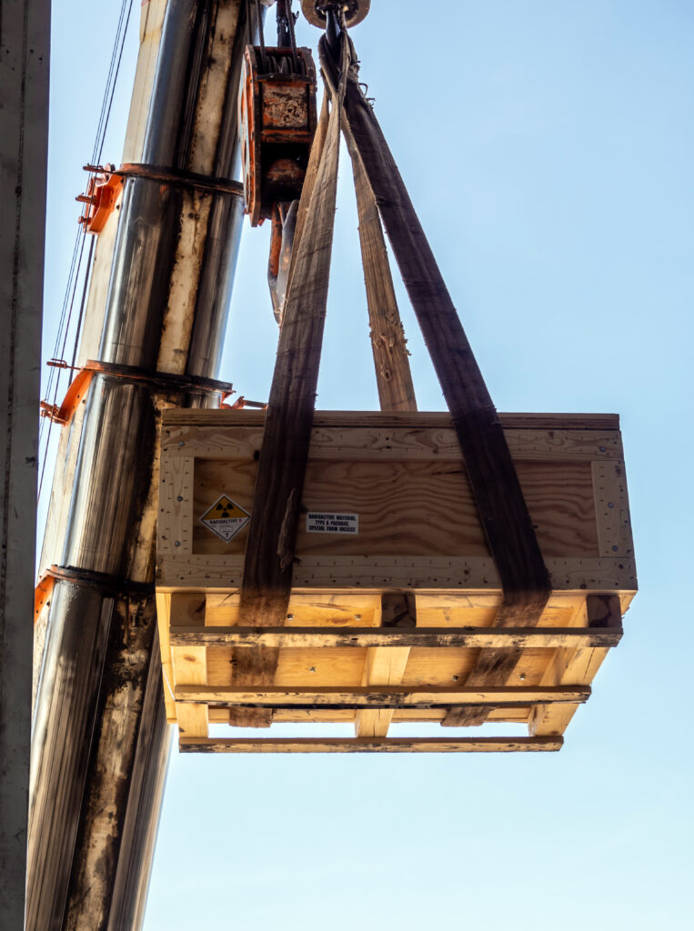 The crane carrying a wooden box of the radioactivity