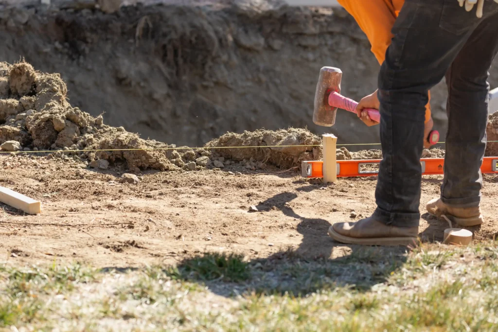 Ground disturbance project with worker near trench, emphasizing trench safety and compliance with excavation regulations.