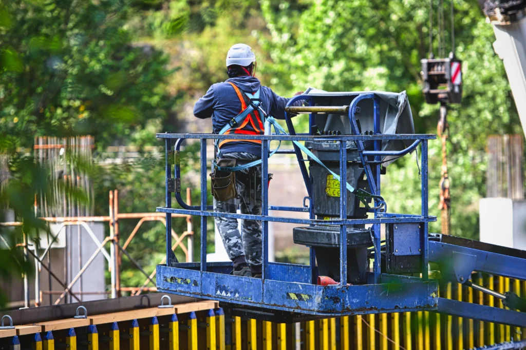Operator on a scissor lift maintaining fall protection to avoid aerial lift accidents and ensure workplace safety